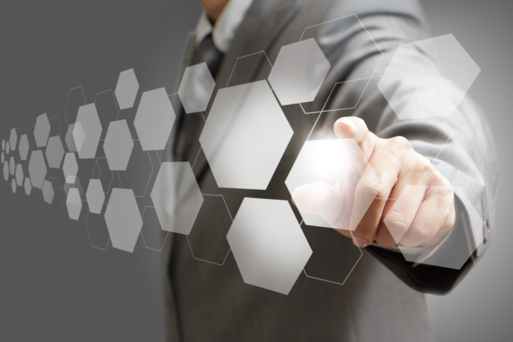 business man hand pushing on a virtual touch screen interface